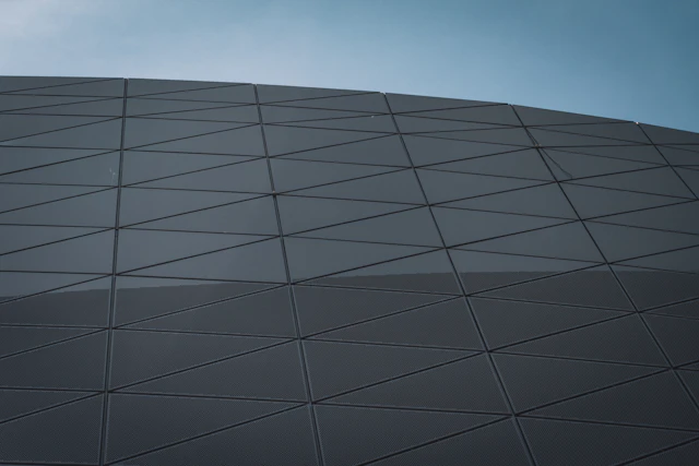 Façade moderne composée de panneaux géométriques aux lignes structurées.