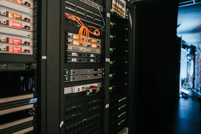 Baies de serveurs et équipements réseau dans une salle informatique.